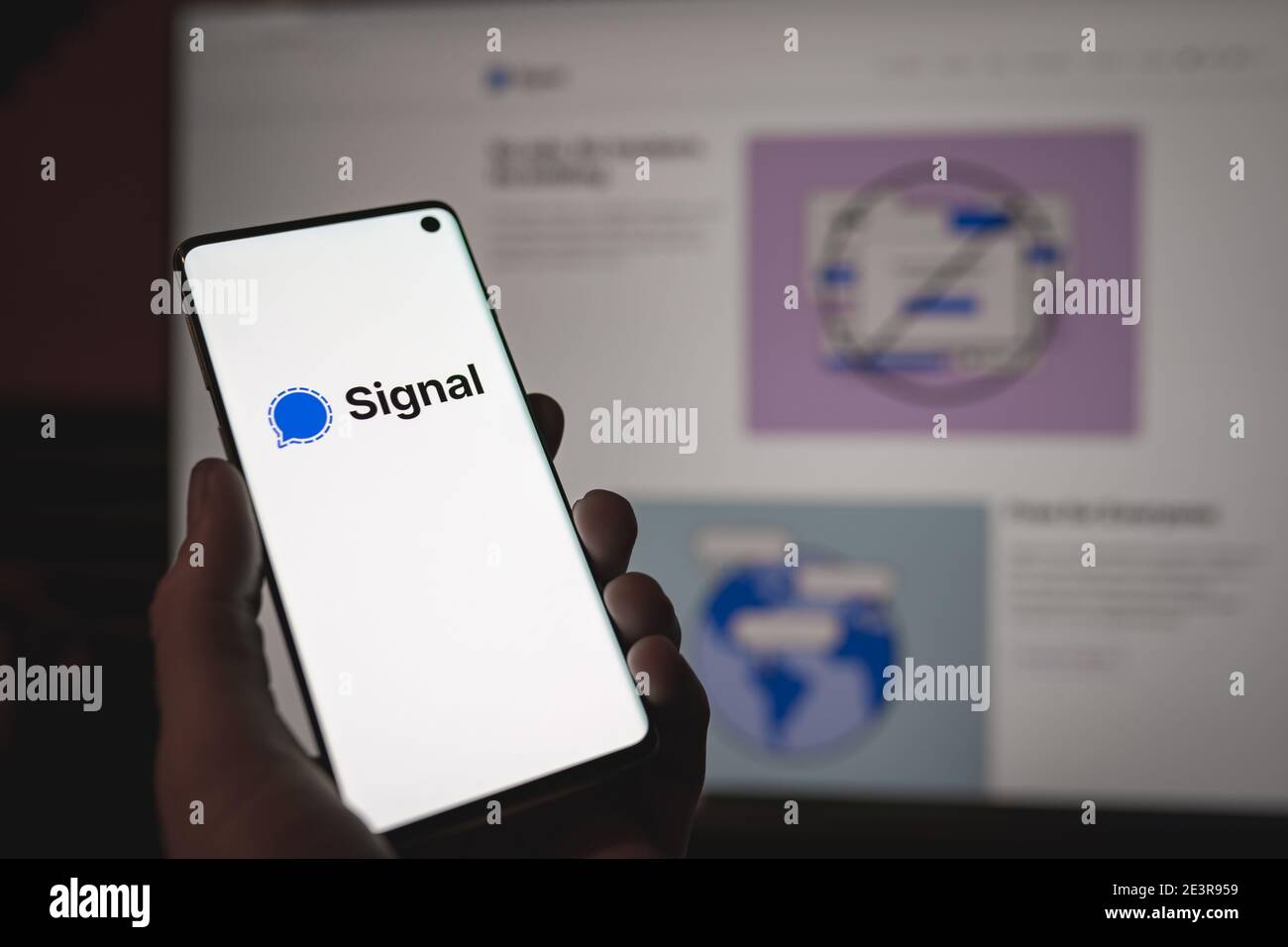 Homme tenant un smartphone avec signe et logo signal wessenger Affiché à l'écran en face de signal web version Banque D'Images