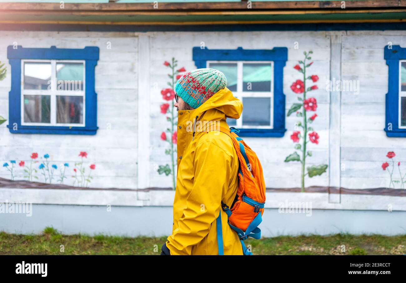 Homme voyageant en face de la maison traditionnelle en bois, Pologne Banque D'Images