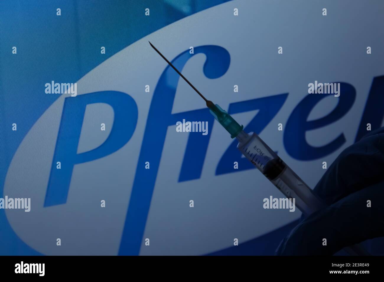 Concept du vaccin Covid-19. Aiguille de seringue, logo Pfizer sur l'arrière-plan. Concept de vaccination contre le coronavirus. Banque D'Images