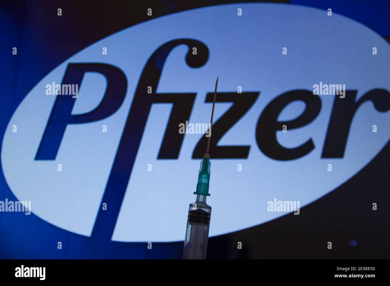 Concept du vaccin Covid-19. Aiguille de seringue, logo Pfizer sur l'arrière-plan. Concept de vaccination contre le coronavirus. Banque D'Images