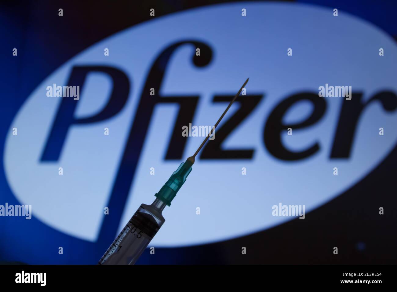 Concept du vaccin Covid-19. Aiguille de seringue, logo Pfizer sur l'arrière-plan. Concept de vaccination contre le coronavirus. Arrière-plan flou. Banque D'Images