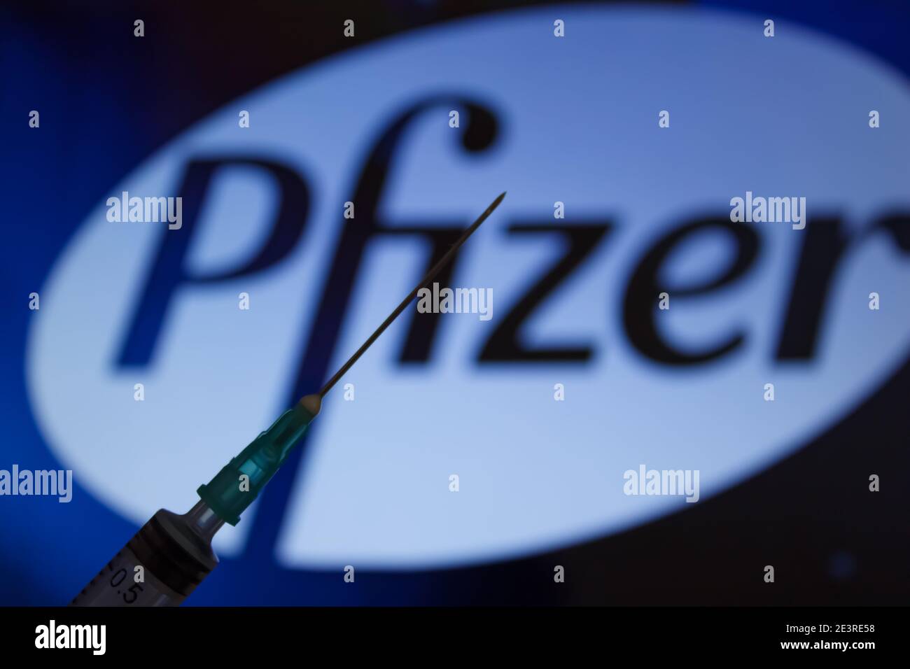 Concept du vaccin Covid-19. Aiguille de seringue, logo Pfizer sur l'arrière-plan. Concept de vaccination contre le coronavirus. Arrière-plan flou. Banque D'Images