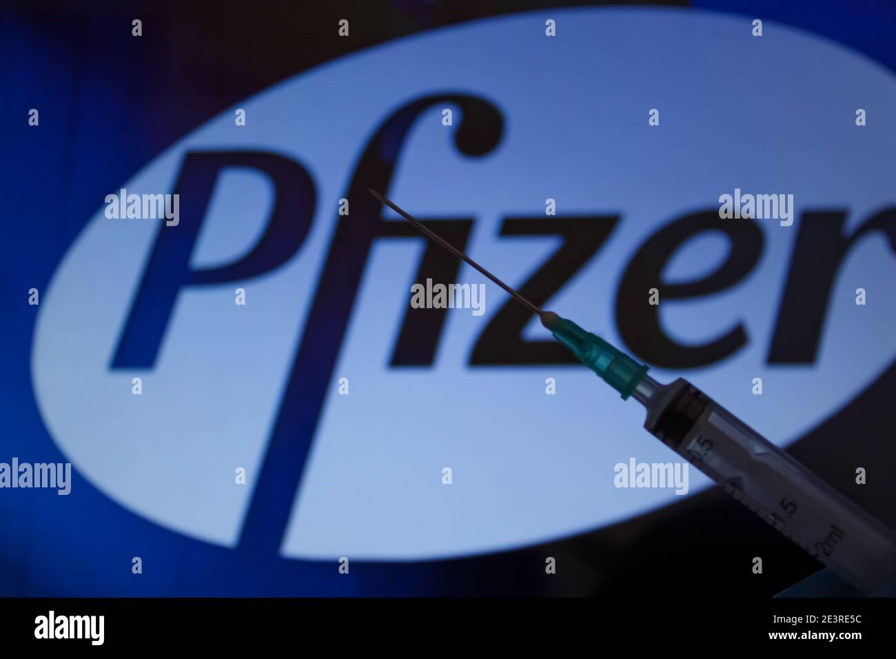 Concept du vaccin Covid-19. Aiguille de seringue, logo Pfizer sur l'arrière-plan. Concept de vaccination contre le coronavirus. Arrière-plan flou. Banque D'Images