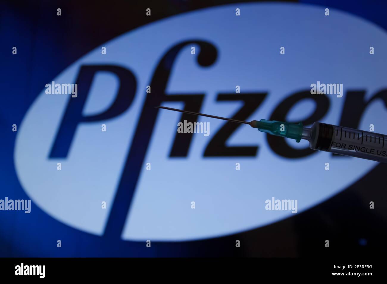 Concept du vaccin Covid-19. Aiguille de seringue, logo Pfizer sur l'arrière-plan. Concept de vaccination contre le coronavirus. Arrière-plan flou. Banque D'Images