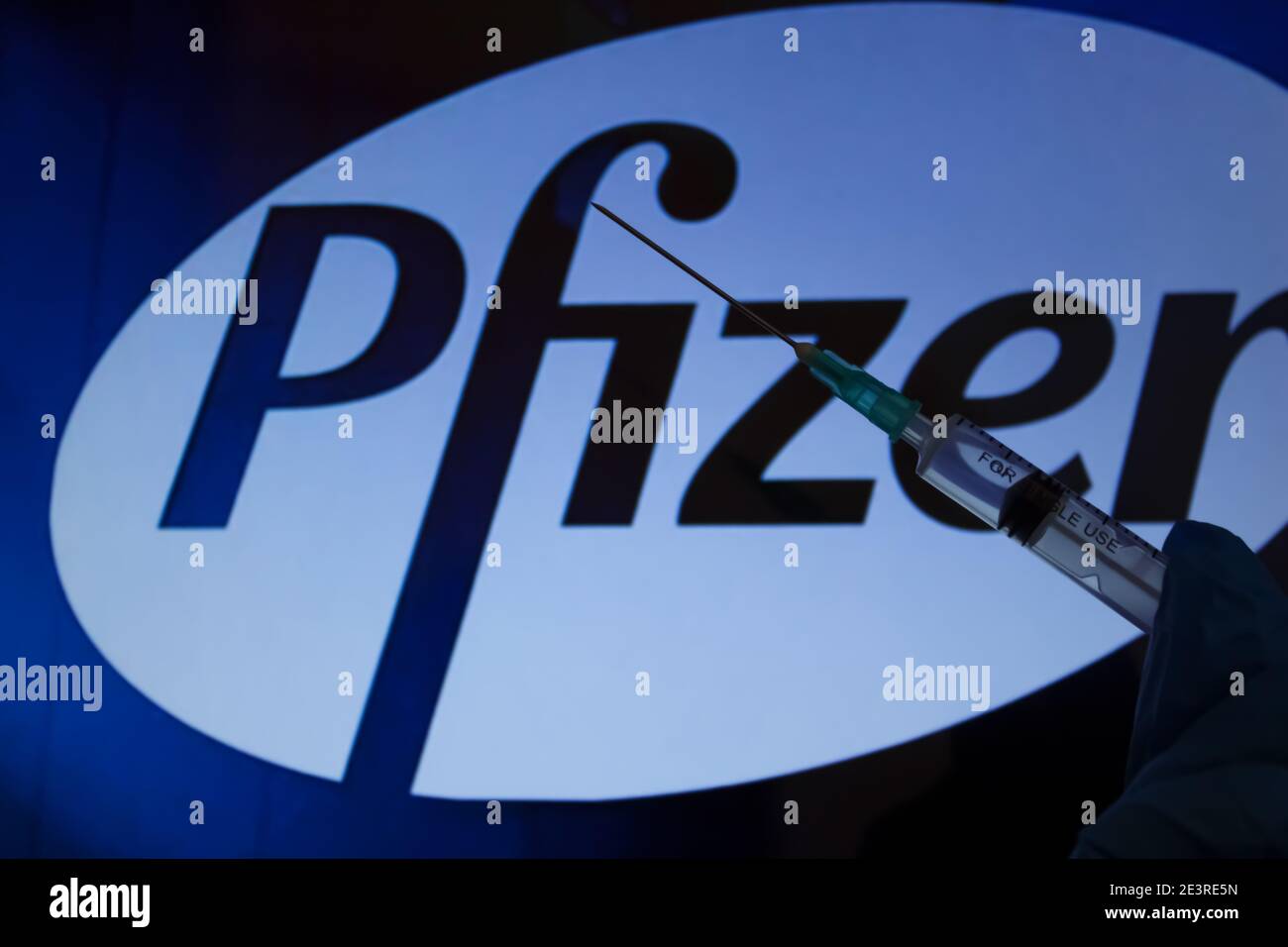 Concept du vaccin Covid-19. Aiguille de seringue, logo Pfizer sur l'arrière-plan. Concept de vaccination contre le coronavirus. Banque D'Images