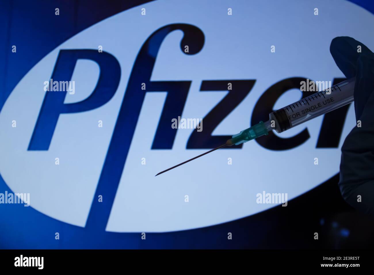 Concept du vaccin Covid-19. Aiguille de seringue, logo Pfizer sur l'arrière-plan. Concept de vaccination contre le coronavirus. Banque D'Images