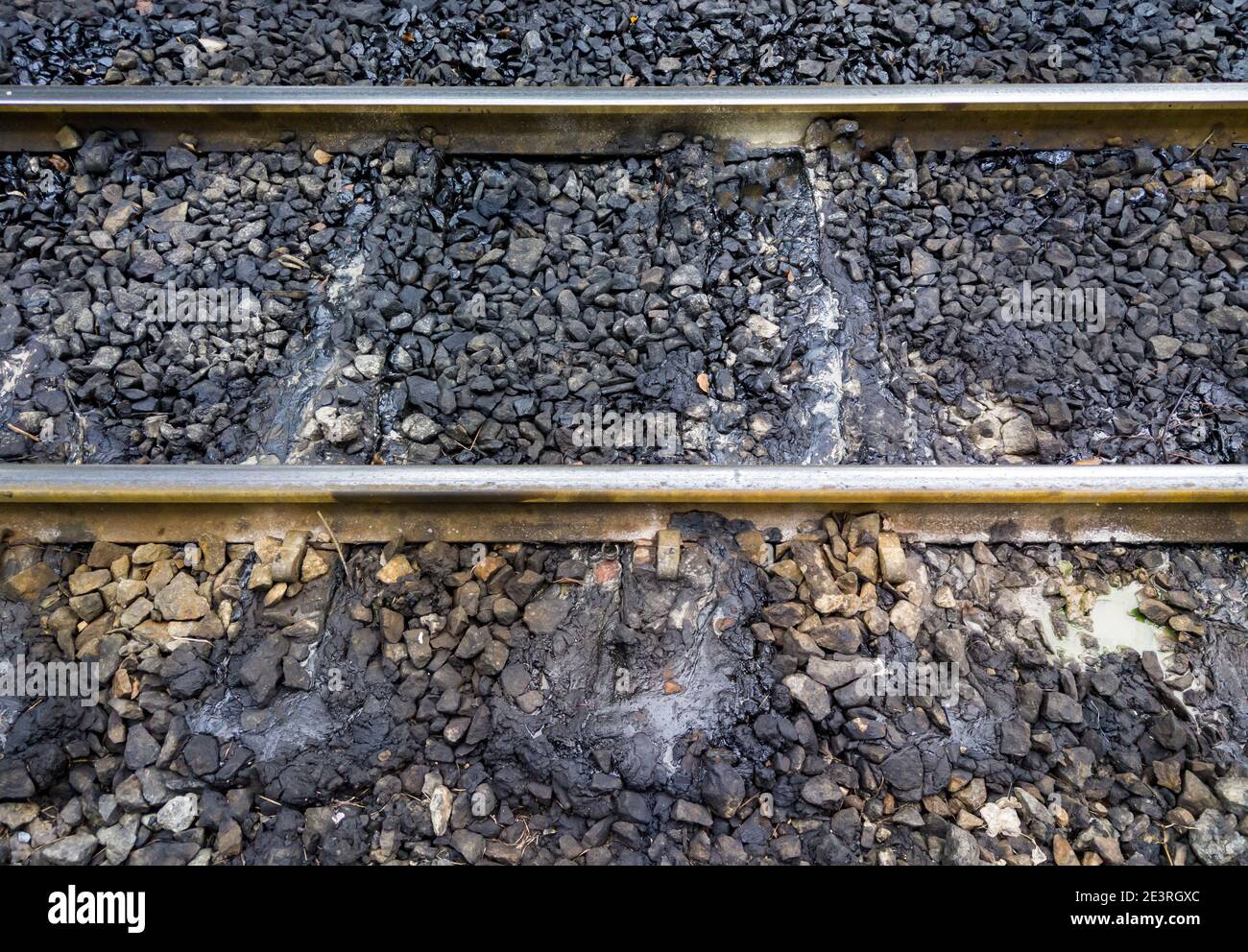 Taches de graisse sur le dormant du chemin de fer près de la plate-forme de la gare, qui est causée par les locomotives diesel à la gare Banque D'Images