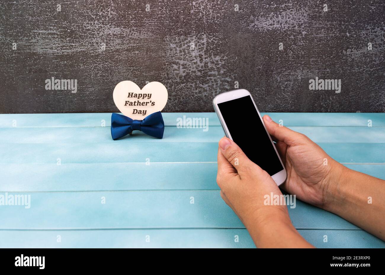 Smartphone entre les mains d'une femme, carte de vœux Happy Pères Day ou affiche avec accessoires pour hommes. Banque D'Images