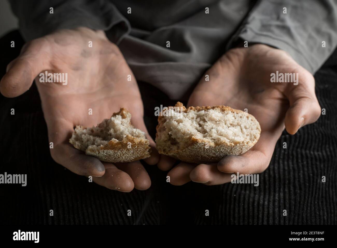 Concept de la faim. Morceaux de pain dans les mains d'un homme. La pauvreté. Banque D'Images