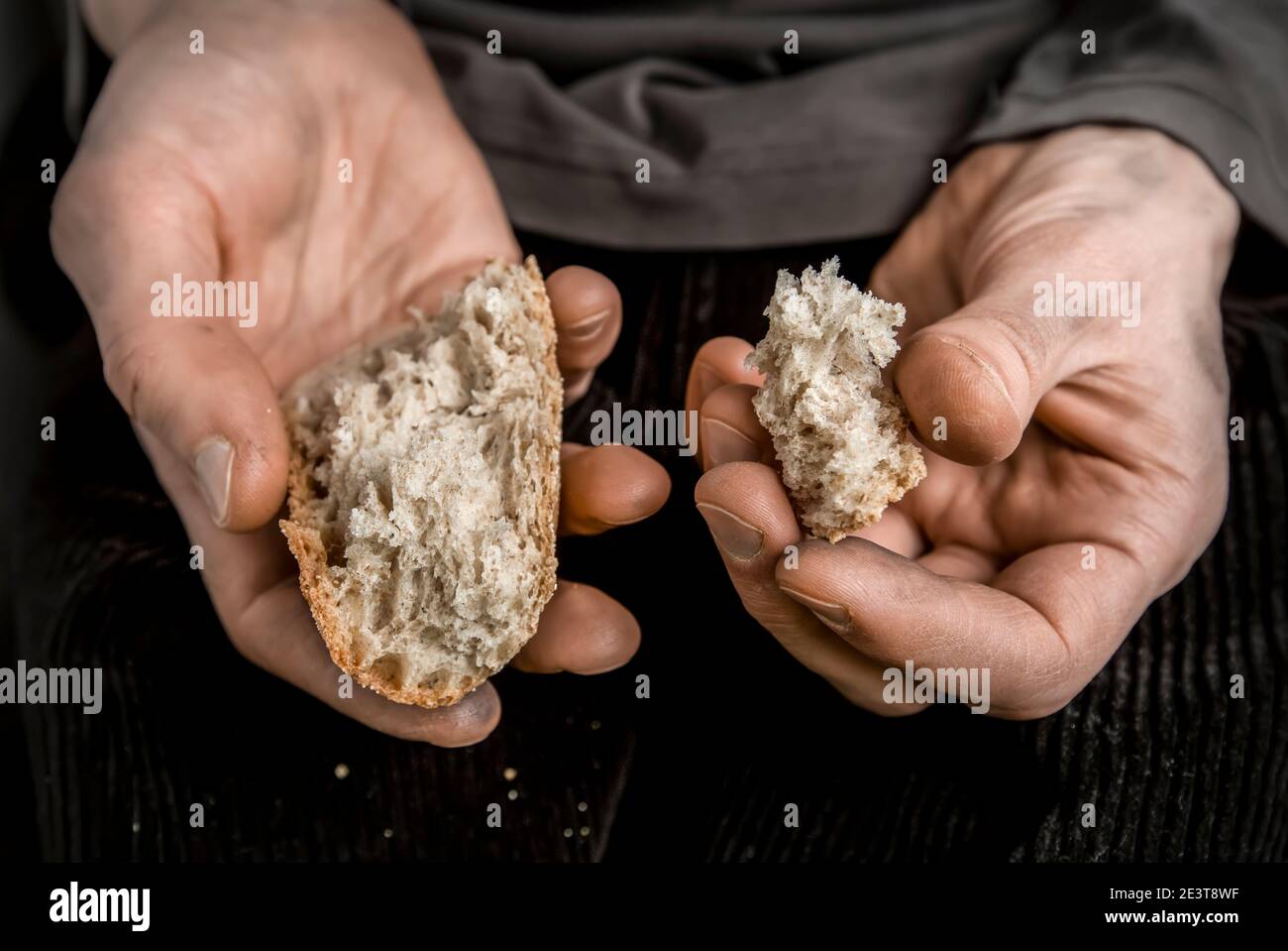 Les mains du pauvre tiennent des morceaux de pain. La faim et la pauvreté. Banque D'Images