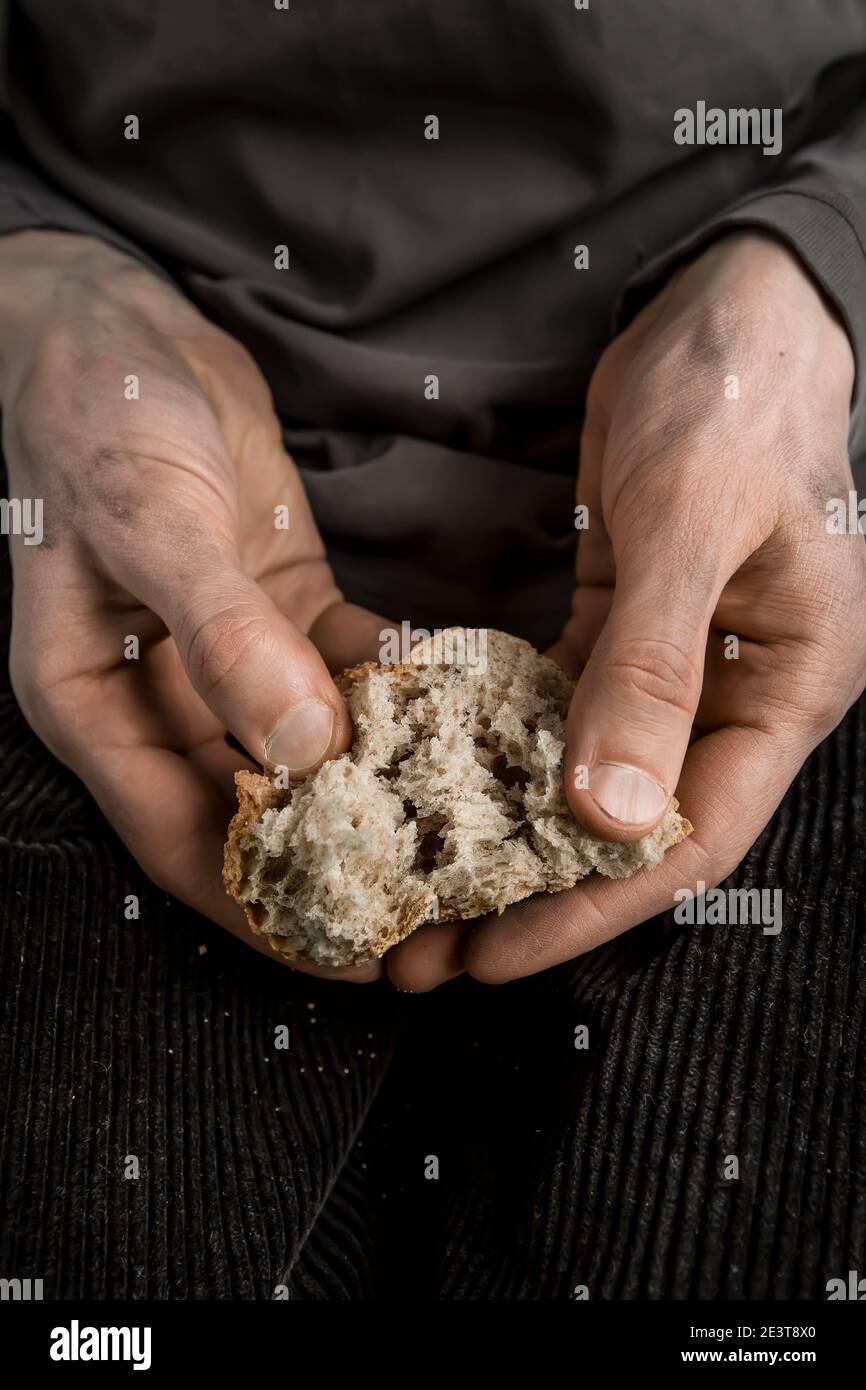 Concept de la faim. Morceaux de pain dans les mains d'un homme. La pauvreté. Banque D'Images