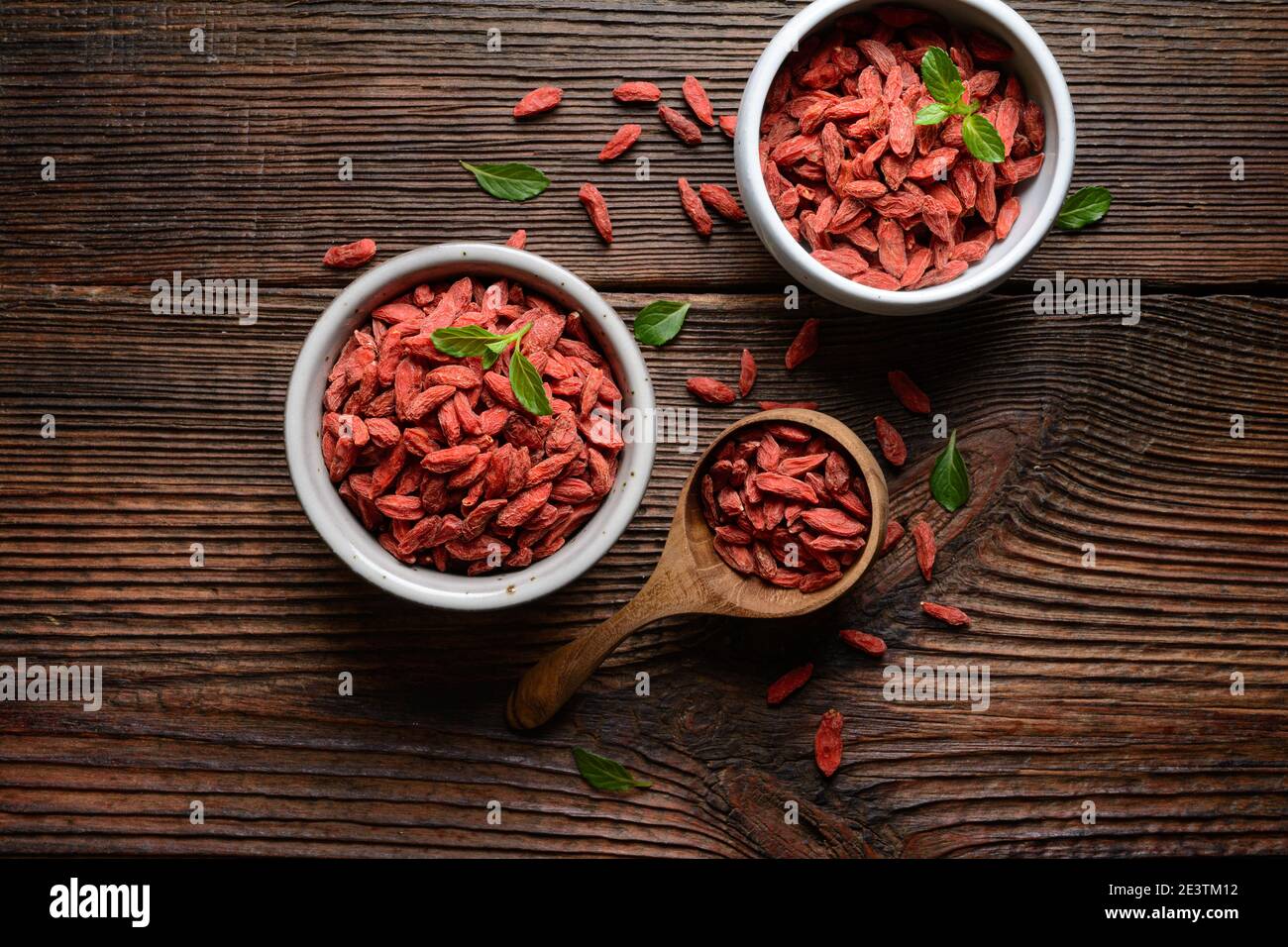 En-cas sain riche en antioxydants et vitamines pour renforcer l'immunité, baies de Goji séchées dans un bol et une pelle sur fond de bois rustique Banque D'Images