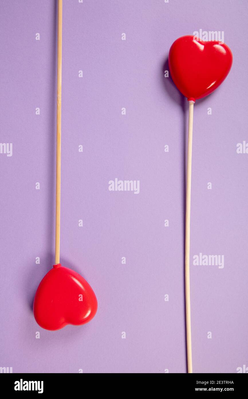 les coeurs sur un bâton se trouvent sur un fond violet Banque D'Images