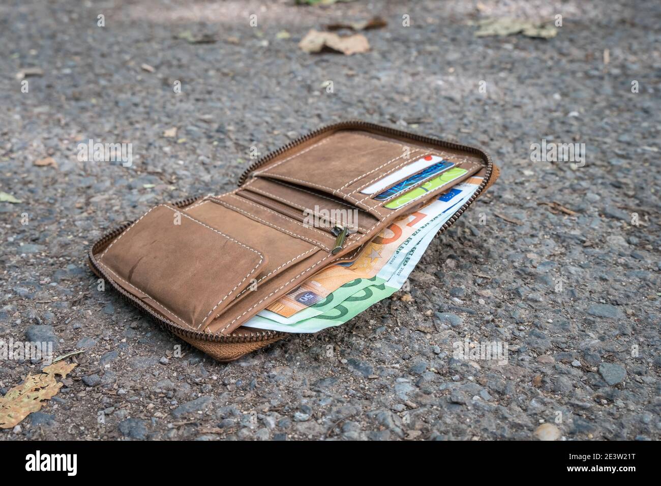 Porte-monnaie en cuir perdu avec de l'argent sur le sol dans la rue Photo  Stock - Alamy