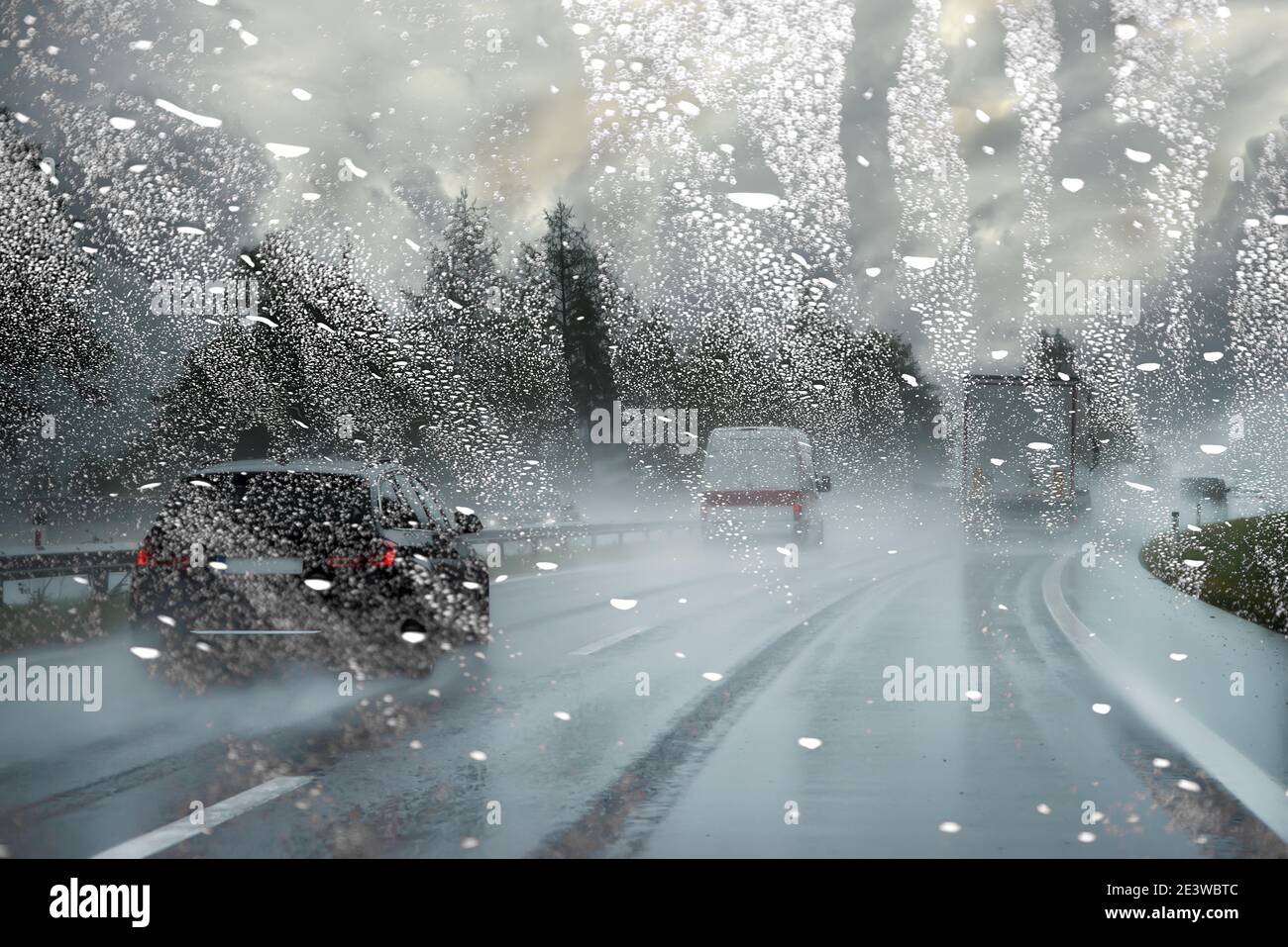 Pare-brise mouillé par la pluie bloque la vue de la route / dangereux voiture floue par temps pluvieux Banque D'Images