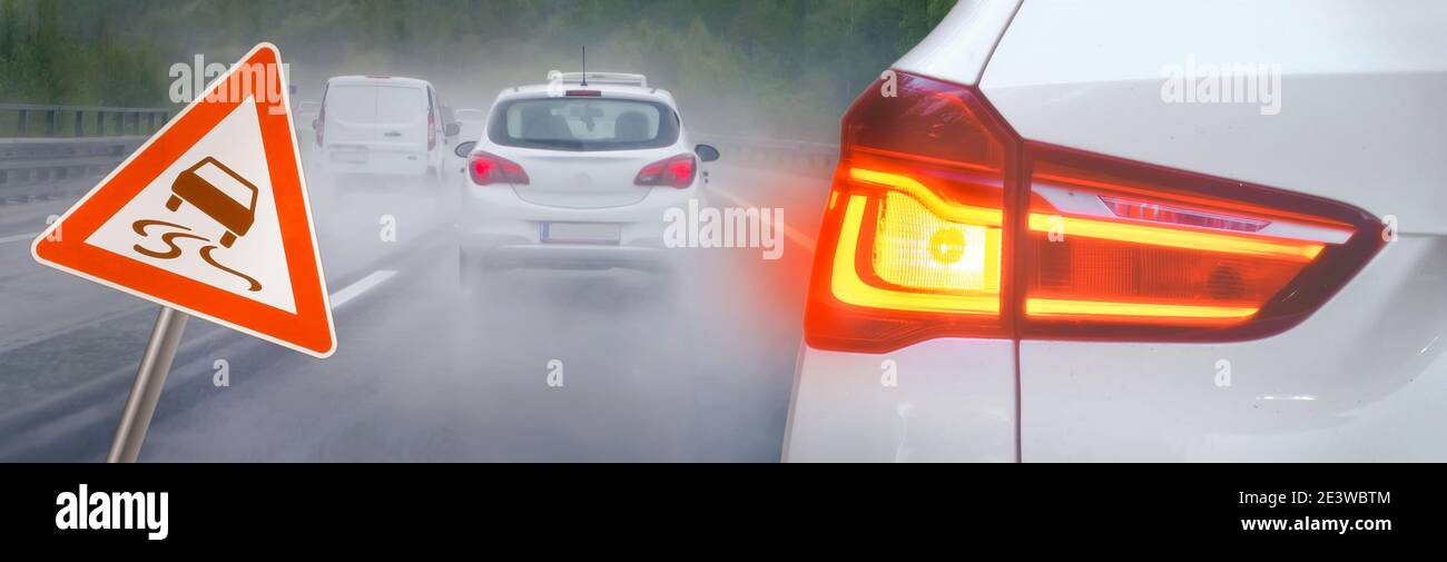 Risque d'accidents sous la pluie et le brouillard sur l'autoroute avec des voitures au freinage et des panneaux de signalisation en dérapage Banque D'Images