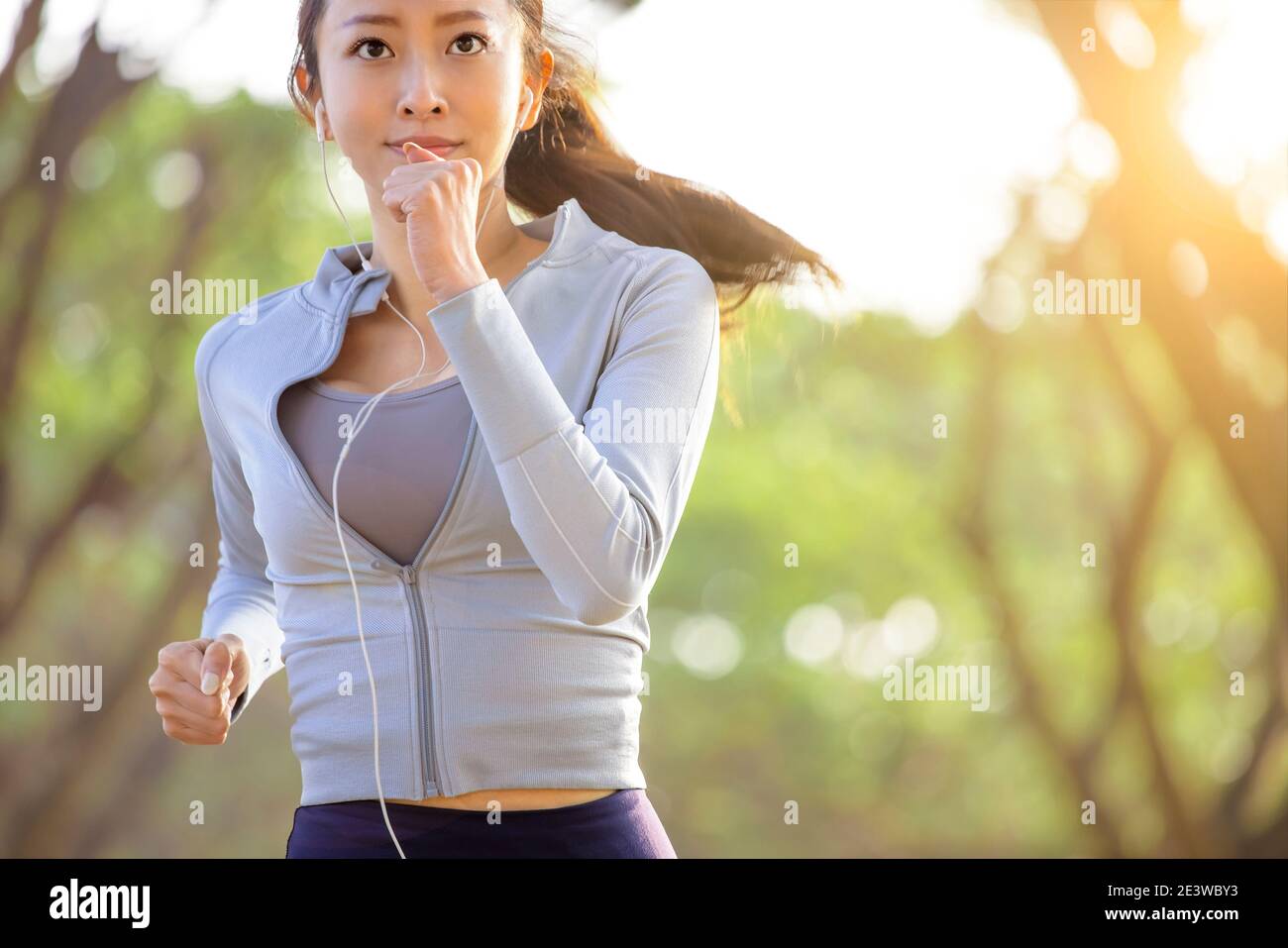 Jeune femme asiatique qui court dans le parc le matin Banque D'Images