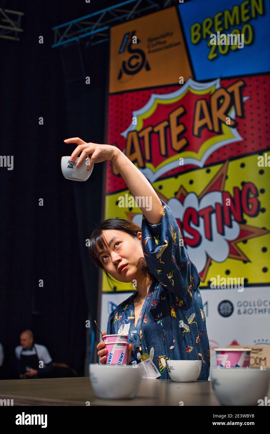 Femme tenant une tasse de café dans l'air au championnat de dégustation de la coupe allemande, 2020 à Brême, Allemagne Banque D'Images