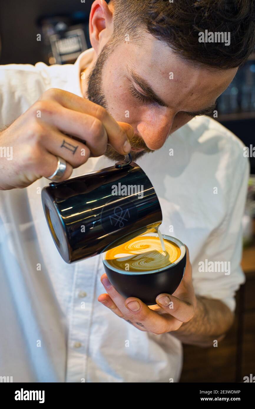 Yuri Marschall, champion d'art latte d'Allemagne, verse du lait chaud dans une tasse de café pour faire du latte Banque D'Images
