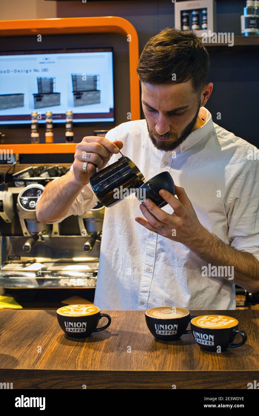 Yuri Marschall, champion d'art latte d'Allemagne, verse du lait chaud dans une tasse de café pour faire du latte Banque D'Images