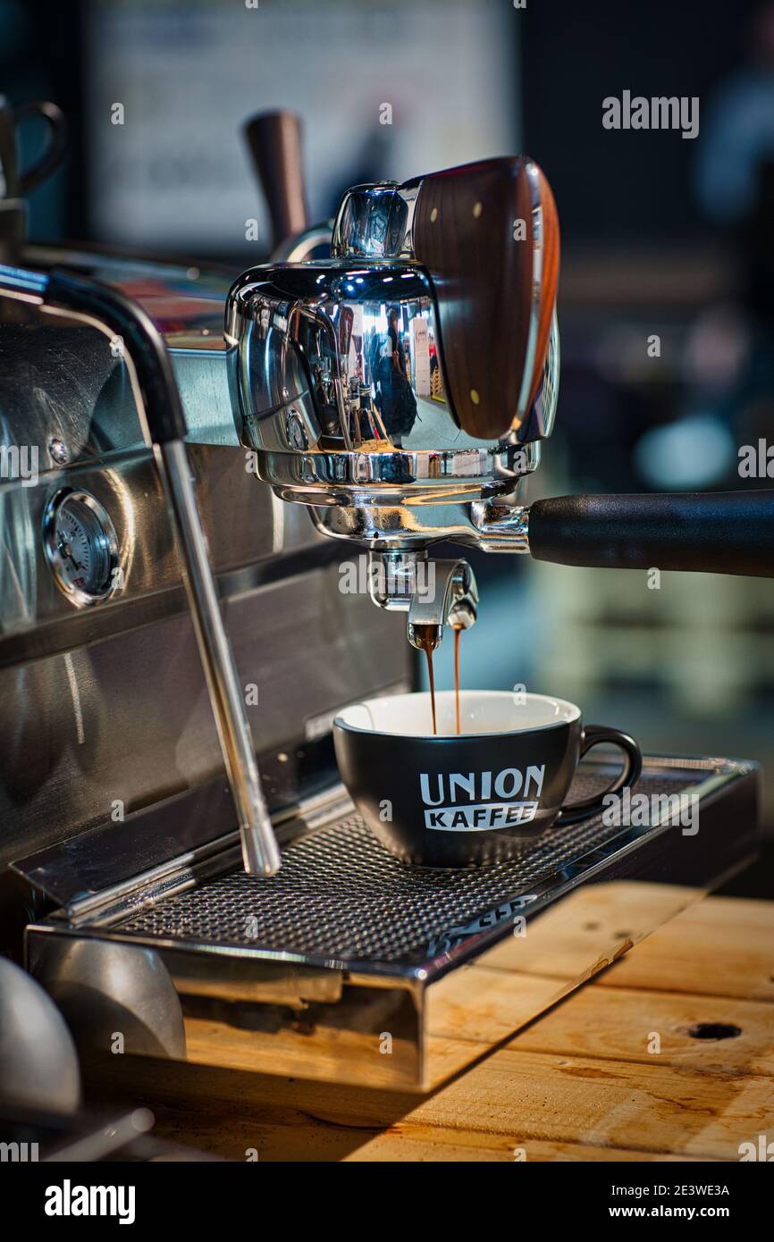 Le café s'égoutte du porte-filtre de la machine à café dans la tasse . Banque D'Images