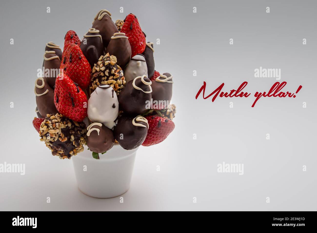 Carte De Vœux Pour Un Joyeux Anniversaire Ou Un Nouvel An En Langue Turque Avec Des Lettres Rouges Indiquant Mutlu Yillar Un Bouquet De Fleurs Comestibles Arrangement De Cho Photo Stock