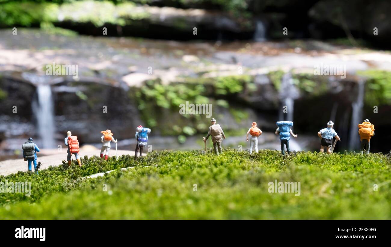 Miniature figure personnes sac à dos debout dans la forêt avec l'arrière-plan de la nature Banque D'Images