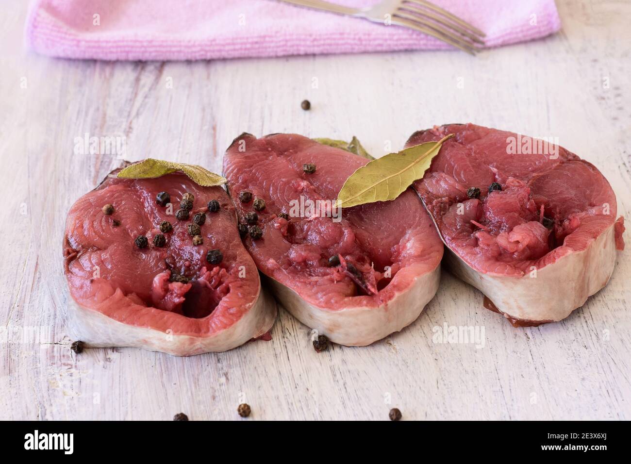 Gros plan sur le filet de thon brut traditionnel Bonito poivre noir et sauge prêts à cuire Banque D'Images