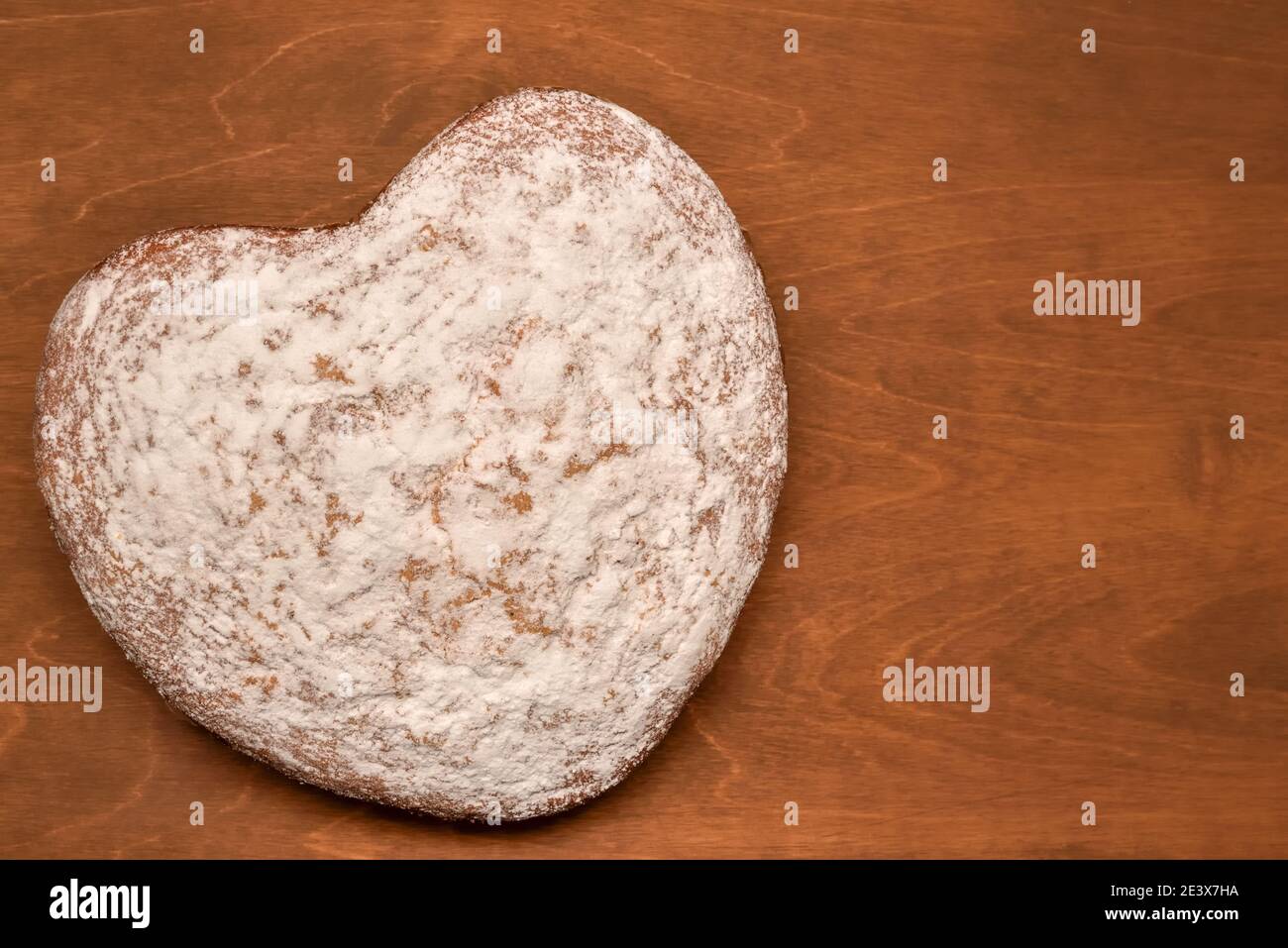 gâteau fait maison en forme de cœur, saupoudré de sucre en poudre, fraîchement cuit pour les vacances Banque D'Images