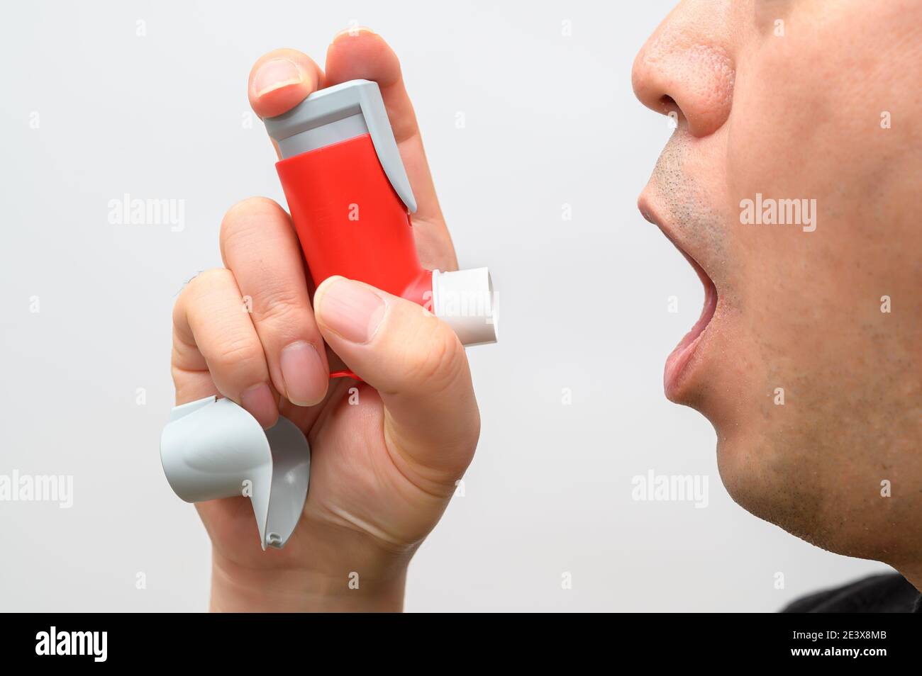 L'homme asthmatique souffre d'asthme et utilise un inhalateur. Banque D'Images