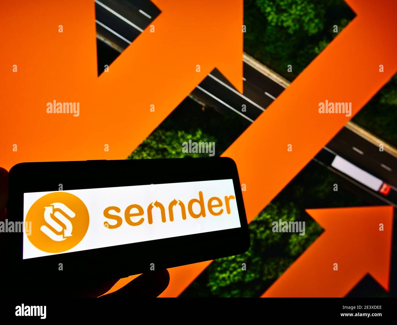 Personne portant un smartphone avec le logo de la société allemande de logistique Sennder GmbH sur le site web. Concentrez-vous sur le centre de l'écran du téléphone mobile. Banque D'Images