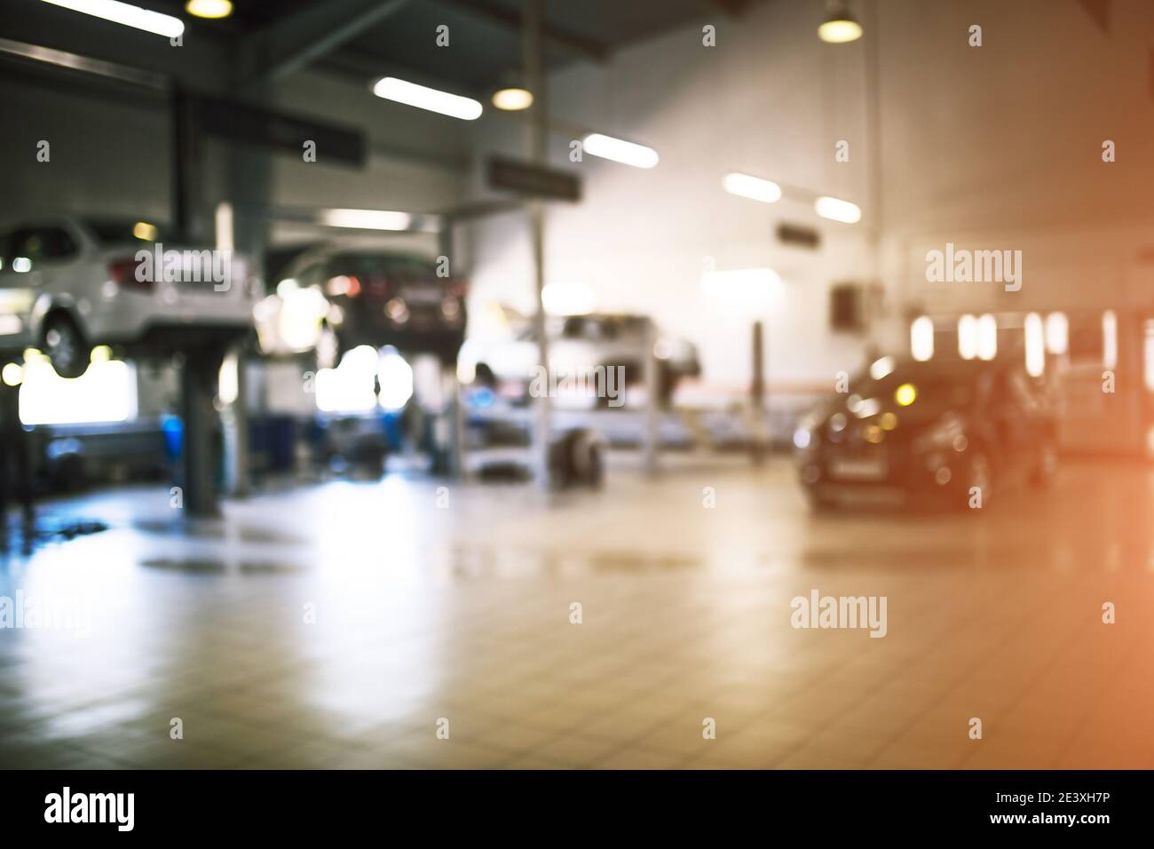 Service de réparation automobile dans un environnement industriel et flou artistique. Voitures sur les ascenseurs, zone de service de transport. Copier l'espace Banque D'Images