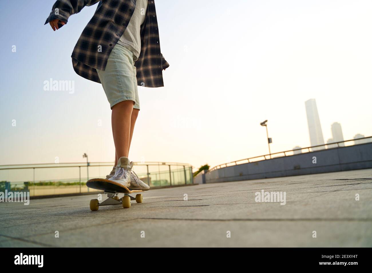 enfant asiatique adolescent skate à l'extérieur sur un pont piétonnier Banque D'Images