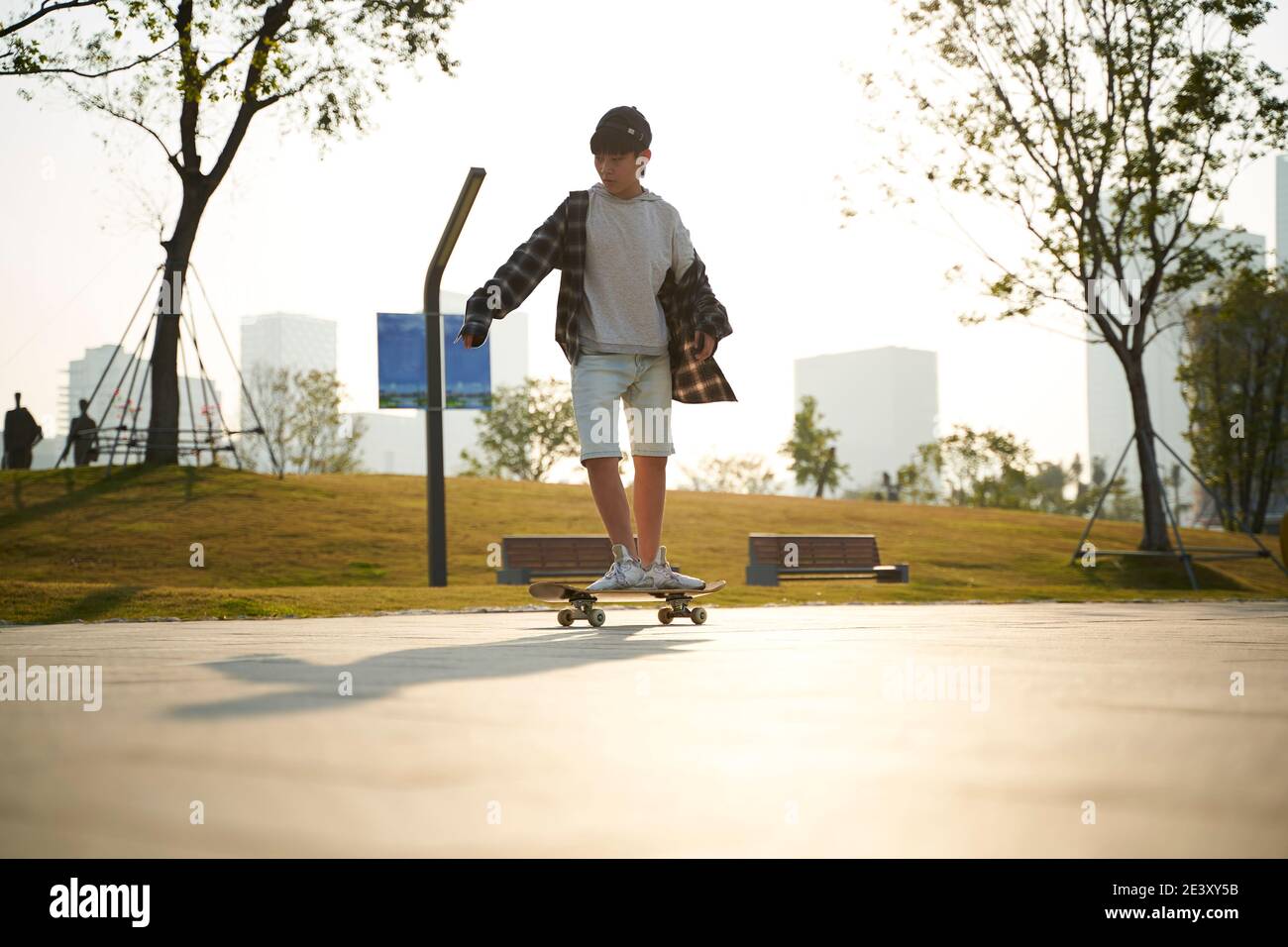 un garçon asiatique qui fait du skateboard en plein air dans la rue Banque D'Images