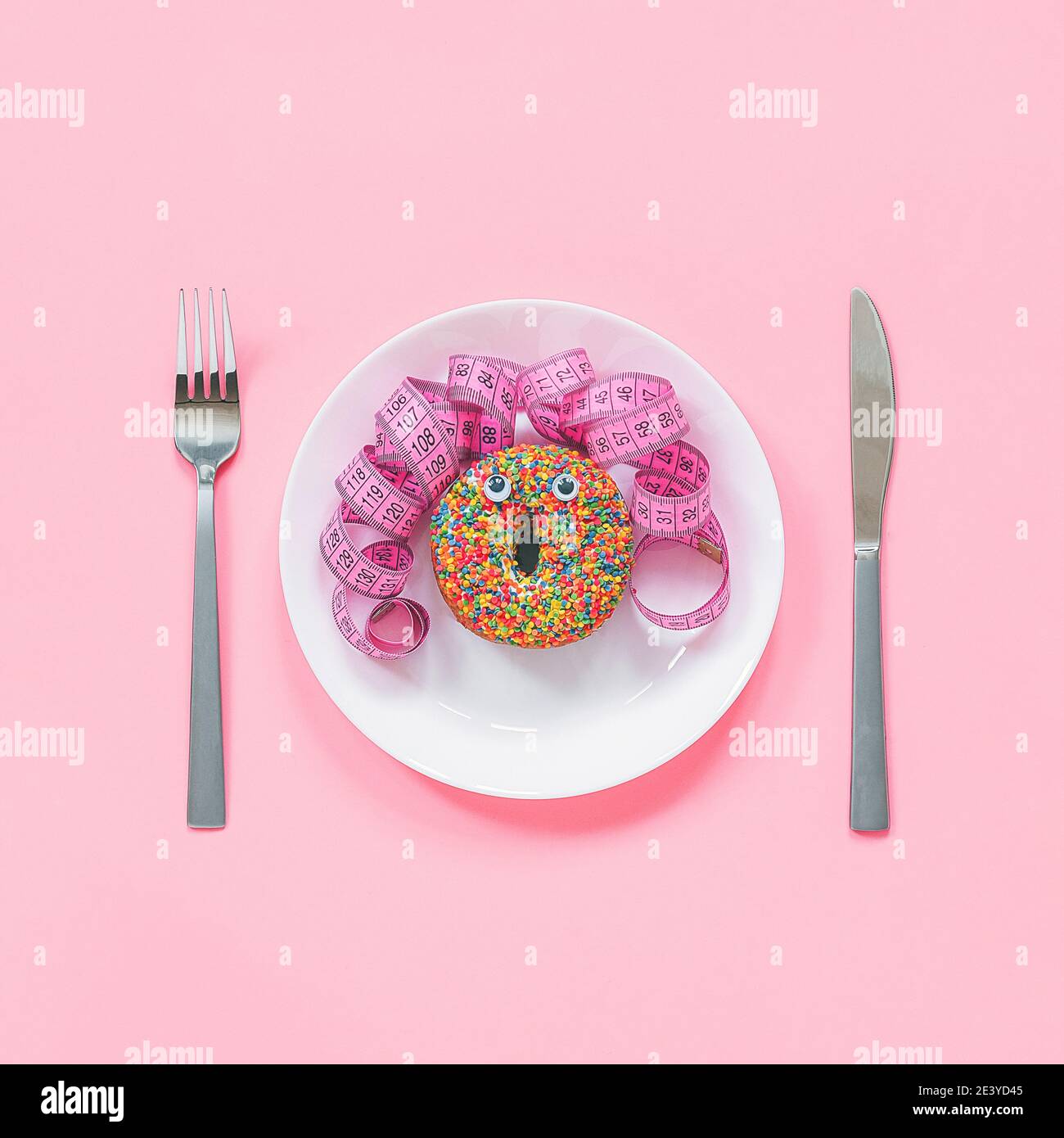 Abstrait visage drôle de la femme fait donut avec les yeux et les cheveux  du centimètre ruban sur l'assiette, coutellerie sur fond rose. Restauration  rapide, engraissement et inhealt Photo Stock - Alamy