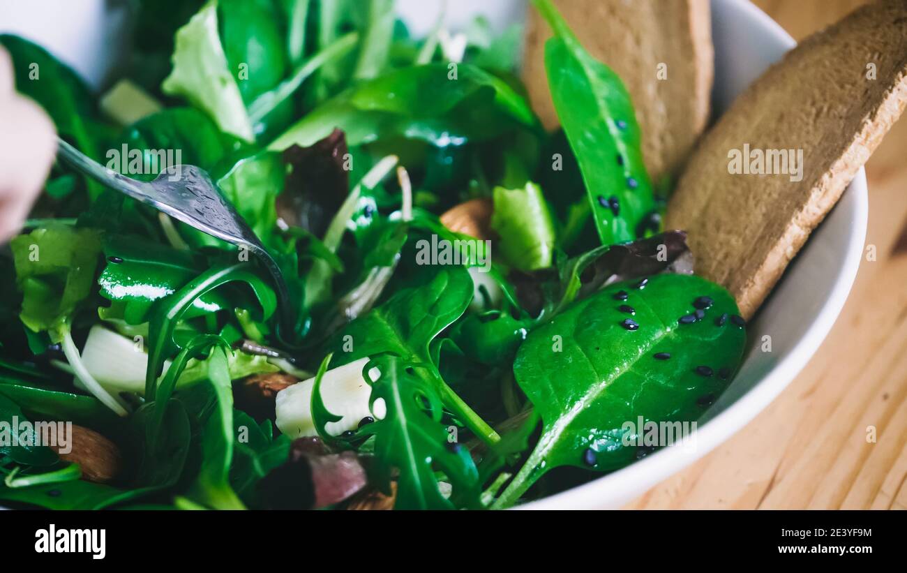 Manger de la salade, gros plan sur un repas de salade. Déjeuner frais et léger. Légumes biologiques, ingrédients naturels pour une alimentation saine. Manger de la nourriture verte. Cuisine Banque D'Images