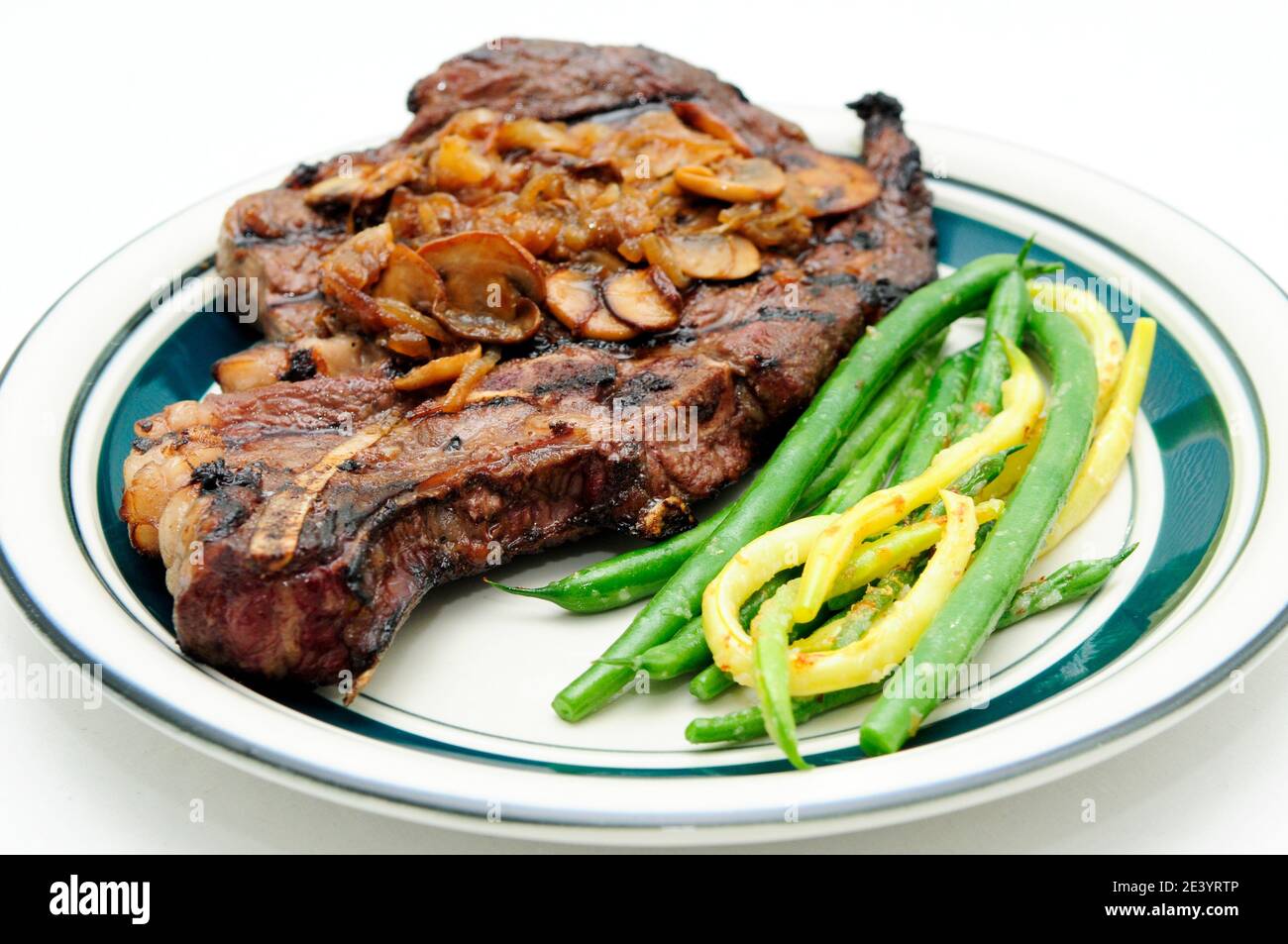 steak de côtes et champignons sautés, oignons et légumes Banque D'Images