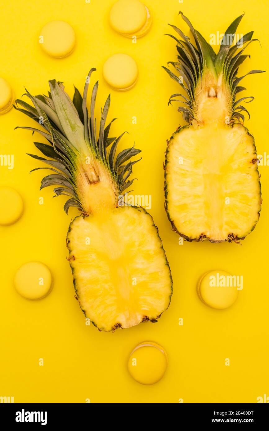 vue de dessus des moitiés de l'ananas juteux et doux isolé sur jaune Banque D'Images