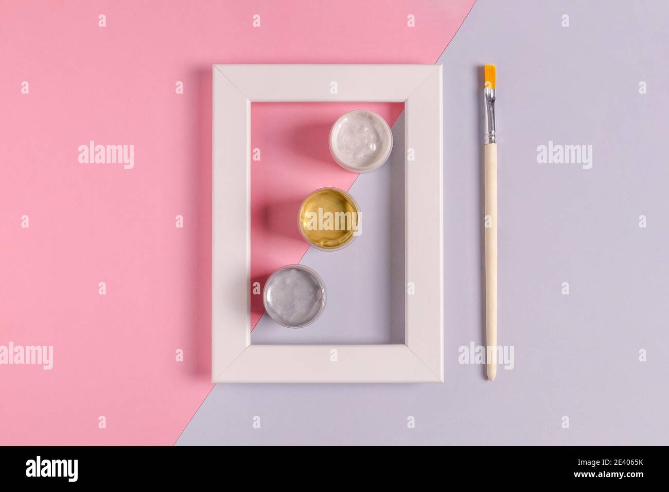 Maquette d'un cadre blanc vierge avec des boîtes de trois couleurs de  peinture acrylique et un pinceau pour la décoration et la peinture. Fond  rose et lilas, minimali Photo Stock - Alamy