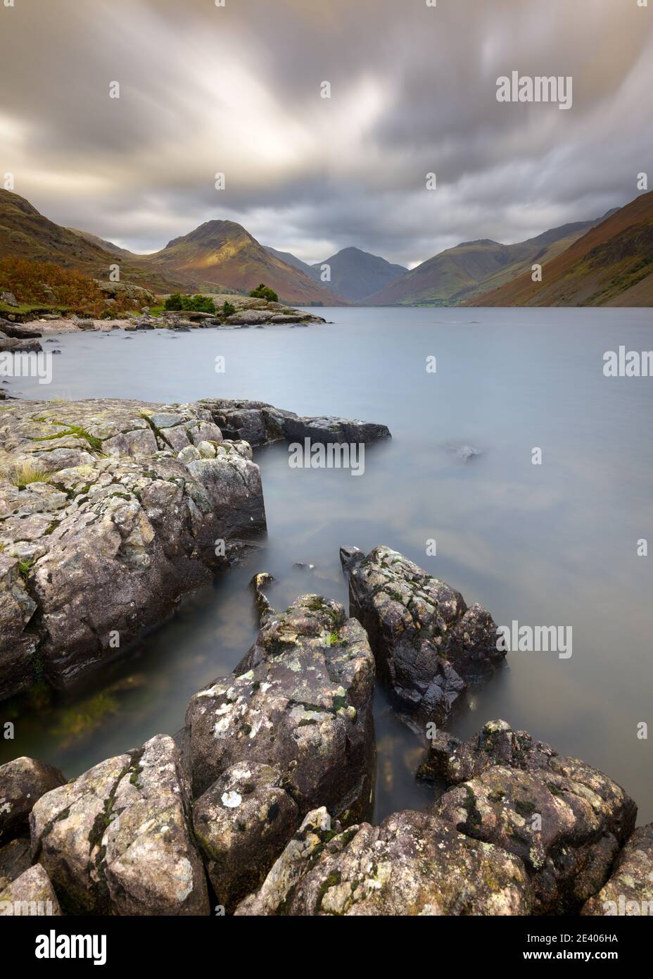 Rochers déchiquetés sur le rivage de Wastwater avec des nuages et des montagnes spectaculaires en arrière-plan. Lake District National Park, Royaume-Uni. Banque D'Images