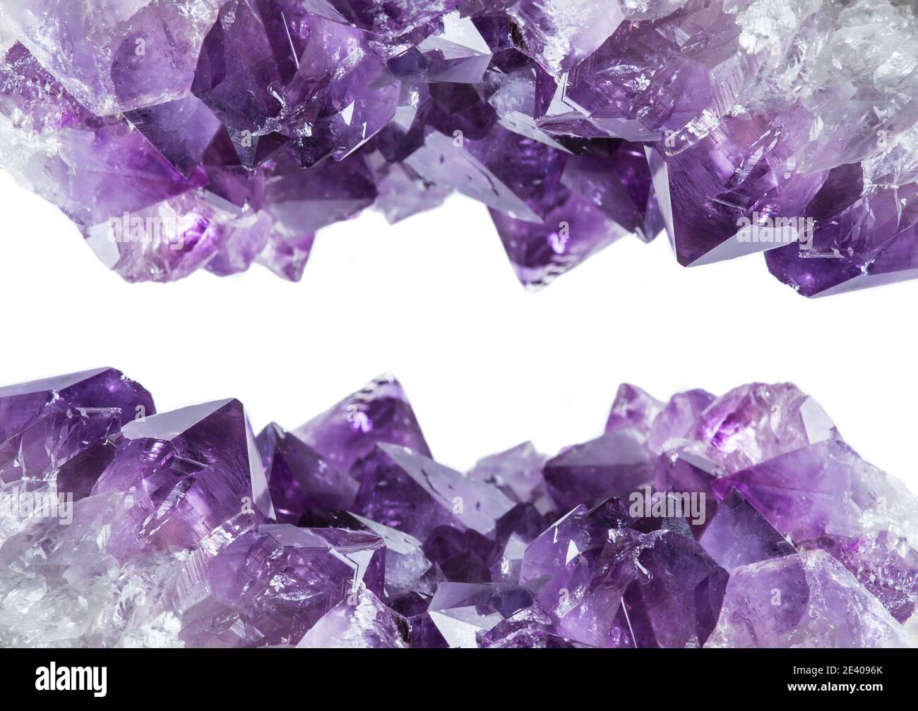 Vue rapprochée de la bordure du grand amas de cristaux d'améthyste violet isolée sur fond blanc. Concept d'arrière-plan magique ésotérique. Banque D'Images