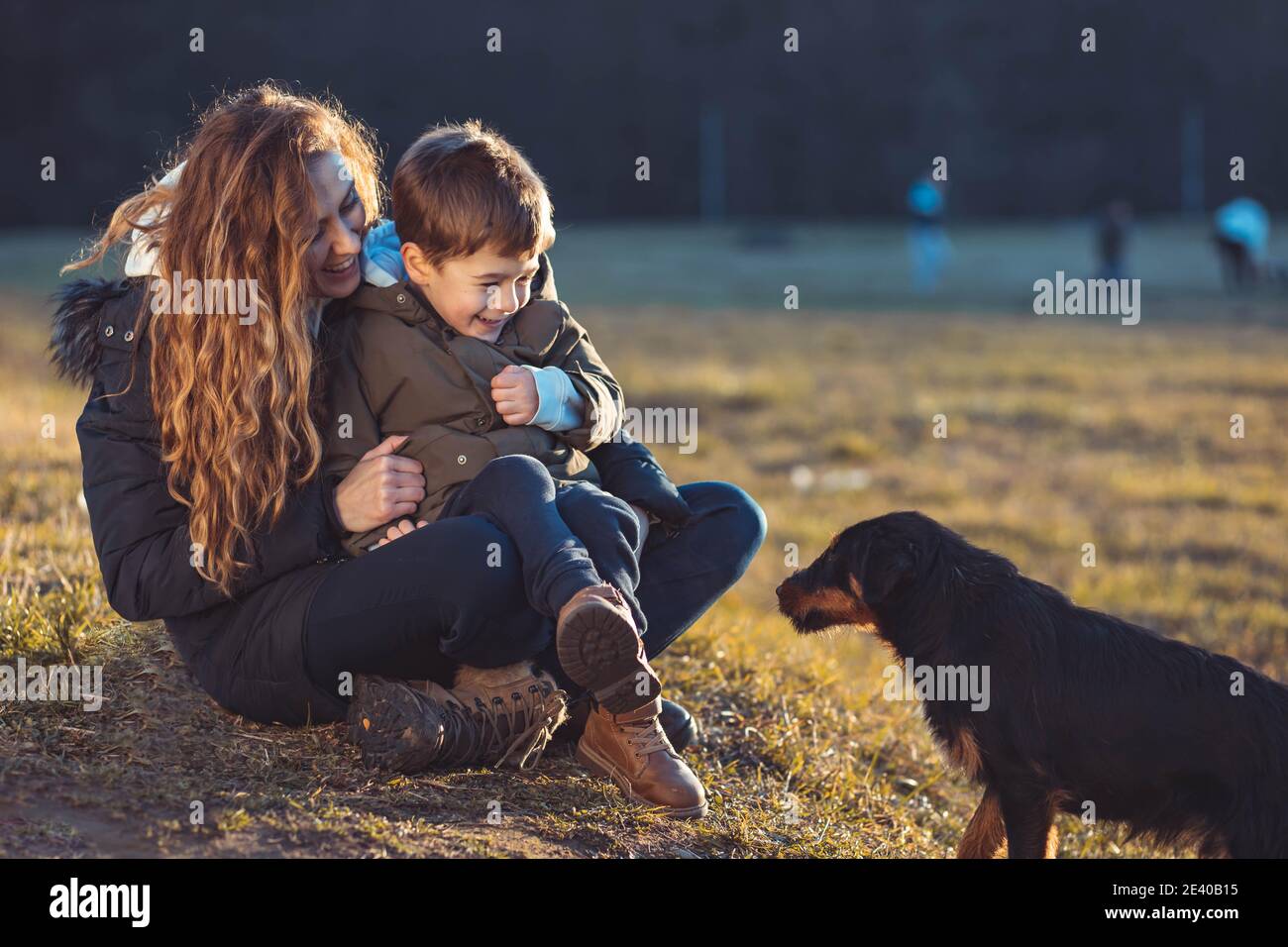 Jeune maman protégeant son fils d'un chien errant Banque D'Images