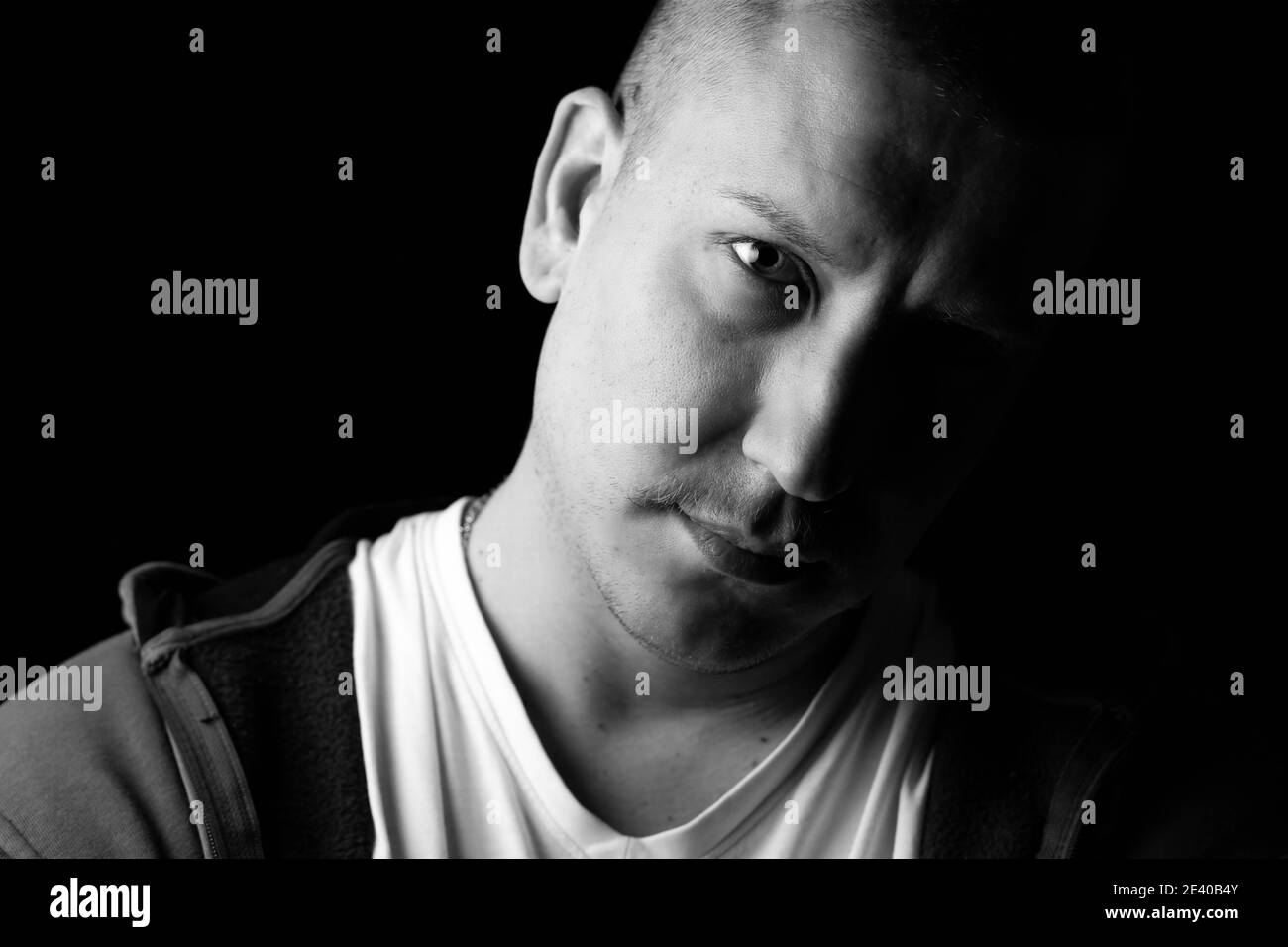 Portrait en gros plan noir et blanc d'un homme fort et confiant. Arrière-plan noir et foncé Banque D'Images