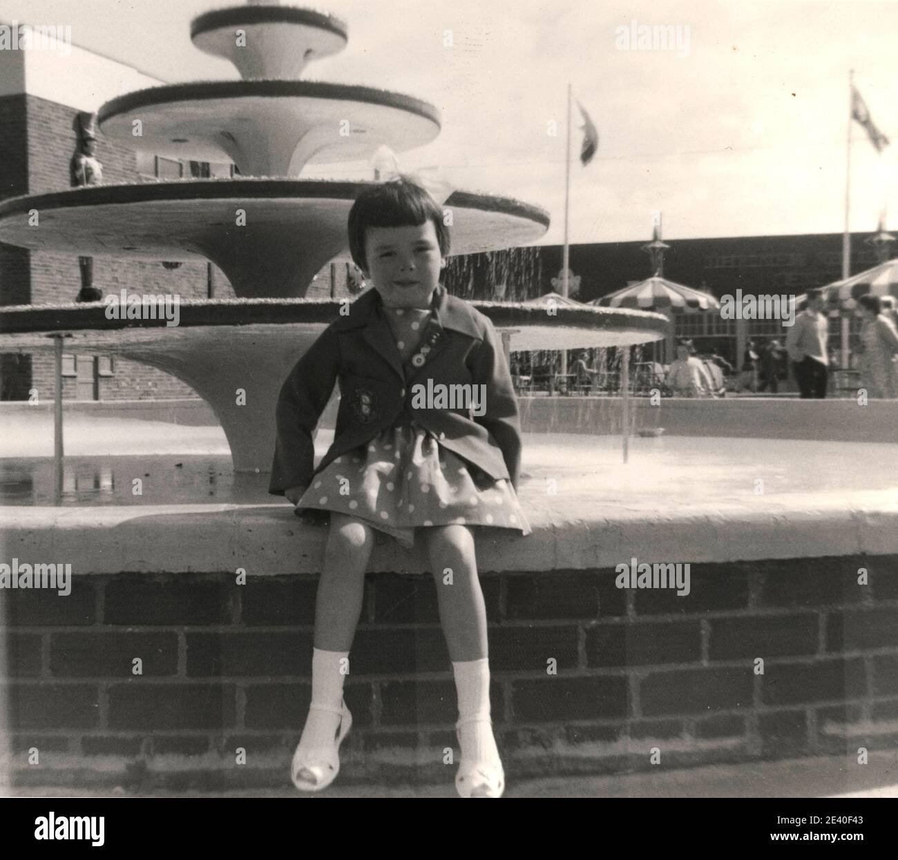 Fille de cinq ans près de la fontaine au camp de vacances de Butlin à Filey, Yorkshire, Royaume-Uni Banque D'Images