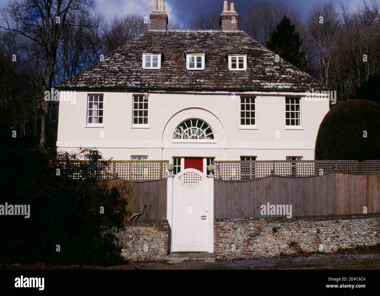 Ancien presbytère géorgien avec des fenêtres de la lunette centrale dans l'arche de soulagement au-dessus de la porte, dortoirs, milton abbas dorset royaume-uni Banque D'Images