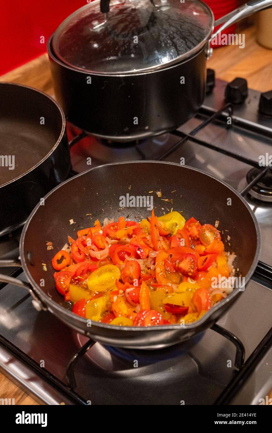 Sauce tomate cerise et poivron rouge en cours de cuisson à la maison comme une sauce pour les pâtes au poivre rouge Banque D'Images