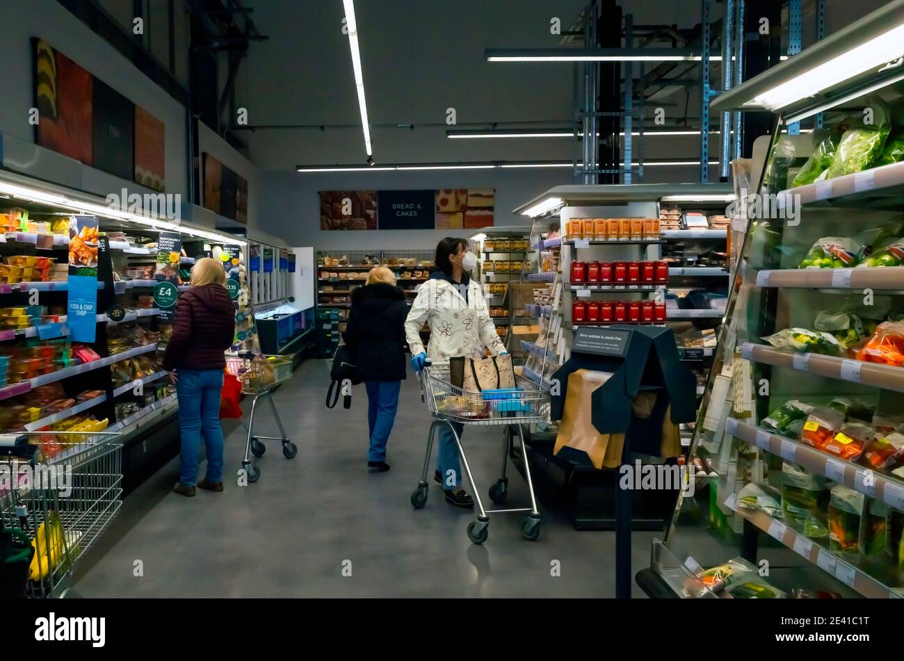 Présentoir de supermarchés de produits surgelés bien approvisionnés fruits et légumes avec trois femmes shopping Banque D'Images