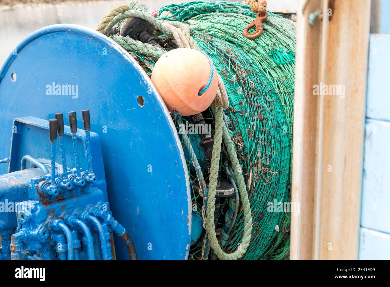 Filets de pêche industriels roulés sur un treuil à bord d'un bateau ou chalutier bleuissant
