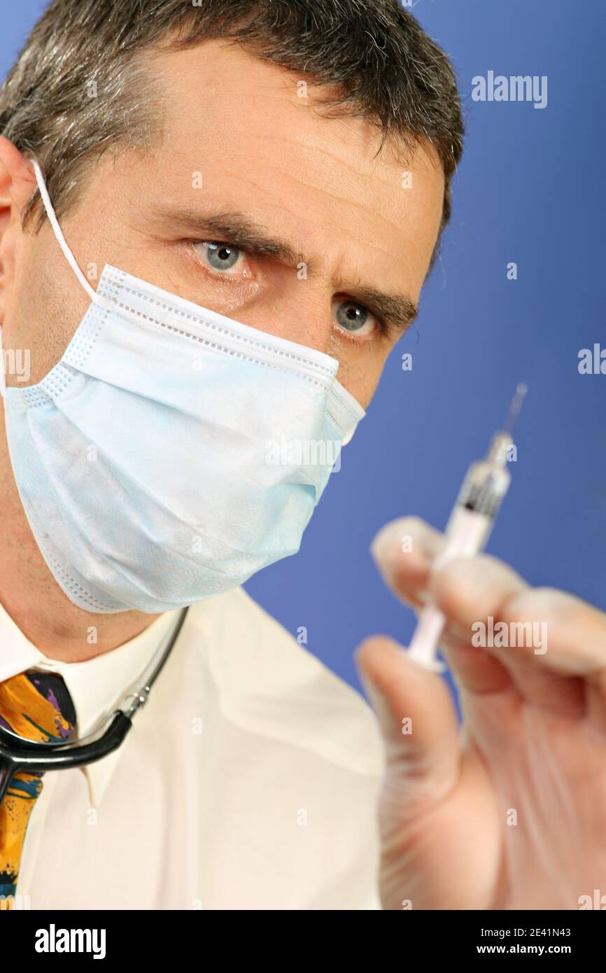 Concept de soins de santé. médecin de 45 ans avec des gants et un masque de protection pour la préparation d'une seringue et d'un vaccin pour la prévention et le traitement du virus covid-19 Banque D'Images