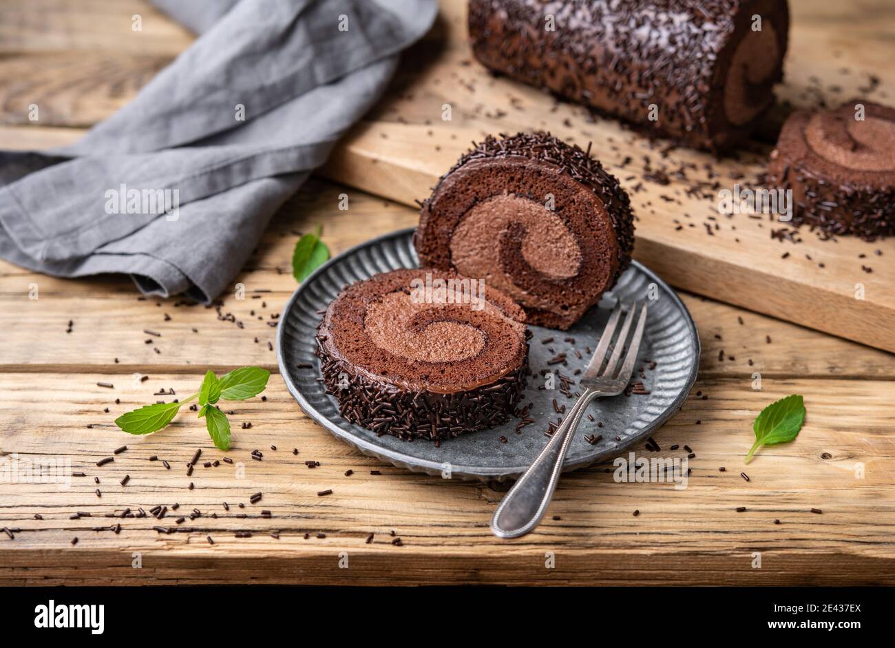 Roule Au Chocolat Avec Garniture Au Cacao Recouvert De Glacage A La Ganache Et Parseme De Copeaux Sur Fond De Bois Photo Stock Alamy